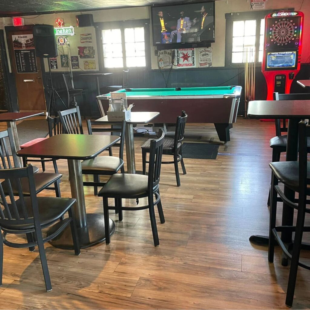 Inside of bar with pool table and speakers.